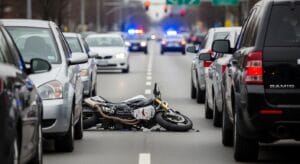 Motorcycle lane filtering crash scene in stopped traffic during a legal investigation